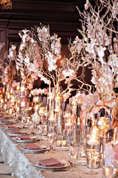 an image of a table with flowers and candles in vases on the top row