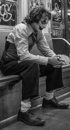 a man sitting on a subway bench with his feet up in the air and wearing socks