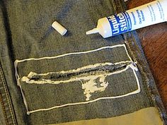 an old pair of jeans is being repaired with glue and toothpaste on it