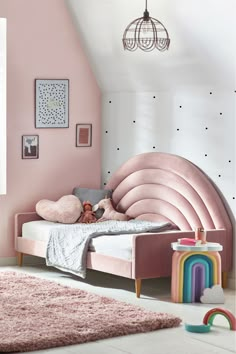 a child's bedroom with pink walls and flooring, including a large bed