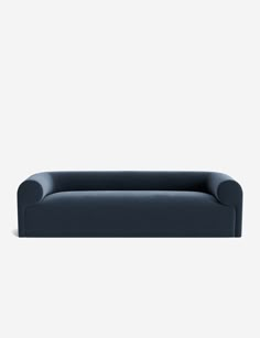 a blue couch sitting on top of a white floor next to a black chair and wall