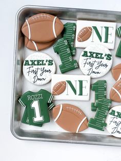 decorated cookies in the shape of footballs with names and numbers are on a tray