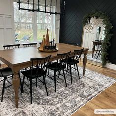 a dining room table with black chairs and a white rug