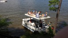 people are sitting on the back of a house boat