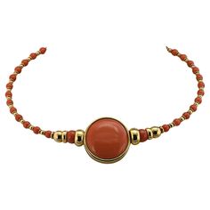 This marvelous 1980 circa Italian necklace is of chic design and beautifully made A large centerpiece of 3 cm. including the gold frame made of the finest flawless quality natural Coral cabochon beautifully polished to perfection, fascinating color, measuring 27.8 mm diameter, nestled into a gold frame circle makes the focal point of this unique necklace With graduated beads of gold and coral set on a gold torque adorning the neckline Chic and unique, looks beautiful when worn Fine condition throughout Further Details Below Metal: 18 Kt yellow gold Hallmarks: Italian assay and maker Gems: 1 round cabochon cut natural coral of 27.8 mm in diameter – 2 natural coral beads of 8.5 mm in diameter - 32 natural coral beads of 4.9 mm. in diameter Measures: length is 40 cm – centre medallion is 3 cm Gold Frame Circle, Frame Circle, Italian Necklace, Large Centerpiece, Designer Necklace, Coral And Gold, Natural Coral, Unique Necklace, Coral Beads