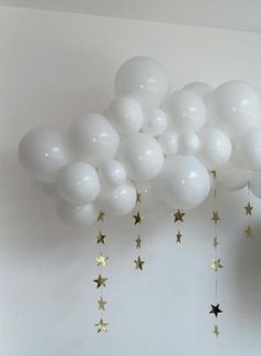 white balloons with gold stars hanging from the ceiling