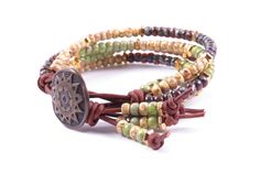 Earthy and elegant. This four-stand beaded leather wrap bracelet boasts a colorful earthy assortment of red-brown Picasso finish, green and canary yellow seed beads, natural brown leather, ad a beautiful antique sun start metal button. Please note: Exact colors may vary due to computer monitors, lighting, and photographic lenses. ©Copyright Via Via Jewelry Designs: All rights reserved. Hippie Bracelet With Colorful Beads, Hippie Brown Bracelet With Colorful Beads, Unique Brown Beaded Wrap Bracelet, Unique Beaded Brown Wrap Bracelet, Unique Brown Wrap Bracelet With Round Beads, Earthy Brown Beaded Wrap Bracelet, Brown Wrap Bracelet With Colorful Beads For Festival, Hippie Brown Beaded Bracelets, Hippie Brown Round Bead Bracelets