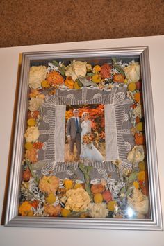 a wedding photo frame with flowers on the bottom and a bride and groom standing next to each other