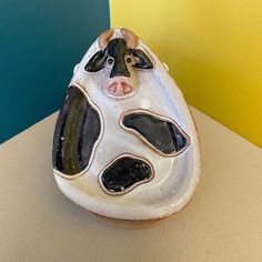 a ceramic cow head sitting on top of a counter next to a blue and yellow wall