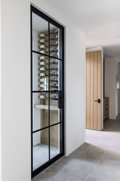 a wine rack in the corner of a room with a door open to another room