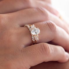 a woman's hand with a diamond ring on top of her finger and an engagement band