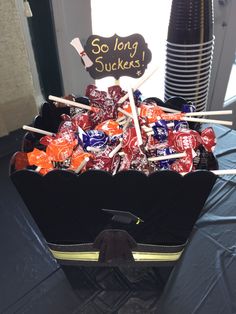 a black suitcase filled with lots of candy and some graduation signs on top of it