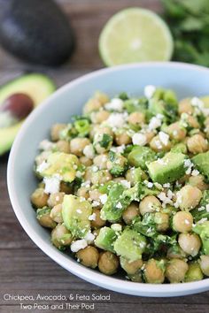 a bowl filled with chickpeas, avocado and feta cheese next to an avocado