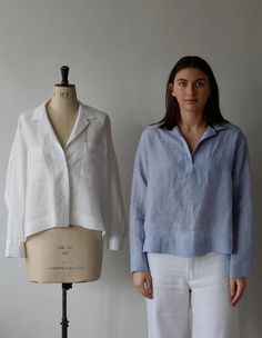 a woman standing next to a mannequin wearing a blue shirt and white pants