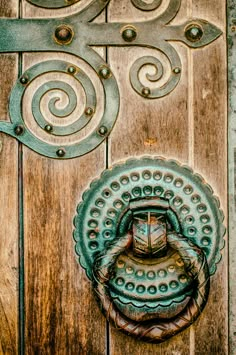 an old door with a metal handle and decorative design on the front part of it