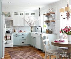 a kitchen filled with lots of white appliances and furniture next to a dining room table