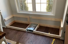 a room with wooden flooring and a window in the corner that has no curtains on it