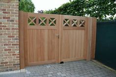 a wooden gate in front of a brick wall