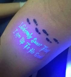 a person's arm with writing on it and blue light coming from behind the arm