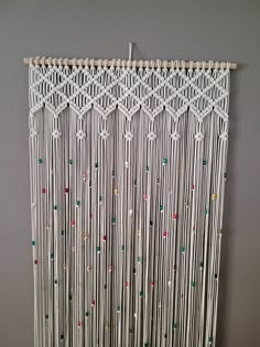 a white wall hanging with beads on it