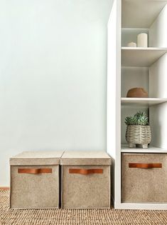 two storage bins in the corner of a room with white walls and carpeted floor