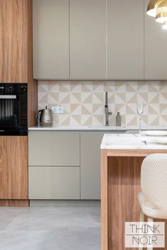 a kitchen with an oven, sink and counter top next to a chair in front of it