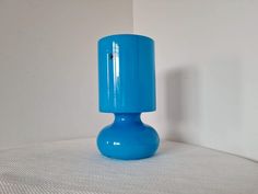 a blue vase sitting on top of a white table