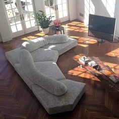 a living room filled with furniture and a flat screen tv on top of a hard wood floor