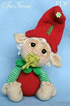 a crocheted stuffed animal wearing a red hat and green scarf