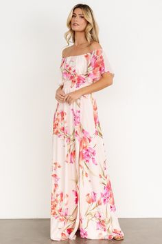 a woman wearing a pink floral print jumpsuit with off the shoulder top and wide leg pants