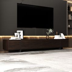 an entertainment center with a large television mounted on the wall and bookshelves in front of it