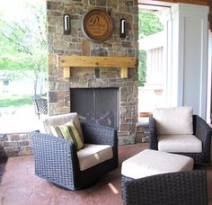 a living room with two chairs and a fire place in the corner, next to a stone fireplace