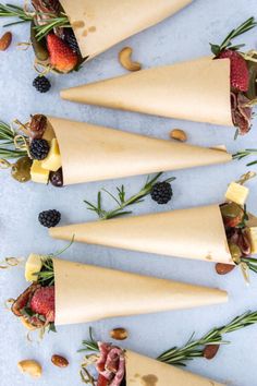 four cones filled with fruit and nuts on top of a table