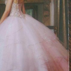 a woman in a pink dress standing next to a mirror