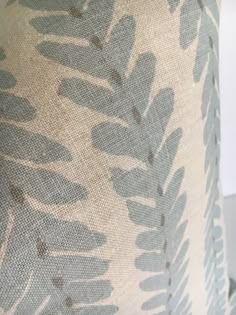 a close up view of a lamp shade with leaves on the bottom and back of it