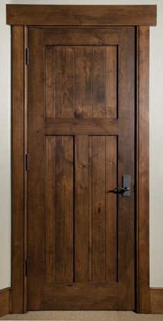 a wooden door in a room with carpeting