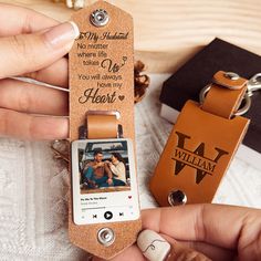 someone is holding up a personalized photo keychain with a leather tag attached to it