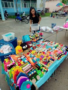 a woman standing next to a table filled with toys