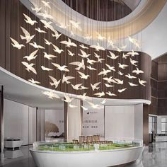 a large white bath tub sitting inside of a bathroom under a chandelier filled with birds