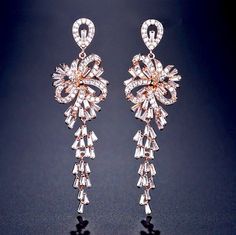 A delightfully unique pair of bridal earrings with an incredible sparkle! Adorned with flawlessly faceted cubic zirconia that capture the light in a dazzling array of sparkles, the earrings are rhodium plated for a bright finish which enhances the intricate detailing and conveys a modern take on old elegance. Length: 60mm (approx. 2.3"). Width: 18mm (approx. 0.7"). Weight: 11g. Available in Silver and Rose Gold finishes. To make your choice select your preferred finish from the dropdown menu to Bridal Earrings Silver, Cubic Zirconia Bridal Earrings, Bridal Jewellery Earrings, Silver Bridal Earrings, Bridal Earrings Chandelier, Wedding Bride Jewelry, Bridal Earrings Drop, Silver Wedding Jewelry, Wedding Party Jewelry