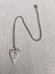 "This is such a unique and whimsical heart pendant necklace. It has incredible detail and another little heart showcased inside the main heart. This would make a very sweet and meaningful gifts for a loved one on any occasion. The heart measures 1\" long by 5/8\" wide and is made from allergy free plated silver. It hangs from a simple 18\" stainless steel necklace chain. I have matching earrings in my shop, if you would like the whole set. Here is the link https://etsy.me/30EwF2x Thanks for stop Bohemian Heart Pendant Charm Necklace Gift, Heart Charm Necklace With Round Pendant, Metal Heart Necklace With Open Heart Charm, Heart Charm Metal Necklace, Bohemian Silver Heart Charm Necklaces, Metal Heart Pendant Necklace, Bohemian Silver Heart Charm Necklace, Metal Heart Pendant Necklace For Valentine's Day, Metal Heart Necklace With Heart Beads