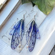 Our very pretty purple faerie wing earrings which are just perfect for any faerie! We make the wings ourselves and they are made from a type of plastic and magic, oh and a sprinkle of glitter of course! The two wings are separate which help create movement Finished with the best quality crystals and a pretty crystal drop, which catches the light perfectly! We make the wings ourselves and they are made from a type of plastic and magic, oh and a sprinkle of glitter of course! The two wings are separate which help create movement. We offer these earrings in sliver plated and bronze plated nickel free earring hooks Please note that no faeries have been harmed in the making of these wings! Villainous Outfits, Vibey Jewelry, Blue Fairy Jewelry For Party, Blue Fairy-style Jewelry For Party, Purple Fairycore Jewelry For Party, Knight Cookie, Earrings Fairy, Tvd Dr, Wing Jewelry