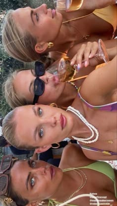 three beautiful women standing next to each other holding wine glasses