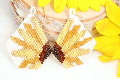 Add a little flower power to your life with our boho seed bead sunflower earrings. These beauties make the perfect statement pieces! Hand beaded dangles shades of sunshine yellow, gold, and mustard that make the perfect gift for a gardener or flower lover. 2.25 inches long 1.25 inches wide They shipped wrapped in tissue & boxed ready to gift or to treat yourself! Each pair is made to order. Shipped in 3-5 business days Yellow Flower Earrings For Summer, Handmade Yellow Earrings For Spring, Bohemian Yellow Sunflower Earrings, Yellow Flower Earrings With Colorful Beads For Gift, Handmade Yellow Flower Beaded Earrings, Yellow Beaded Earrings With Tiny Beads As A Gift, Yellow Beaded Earrings With Ear Wire For Summer, Handmade Yellow Beaded Bohemian Earrings, Summer Yellow Beaded Earrings With Ear Wire