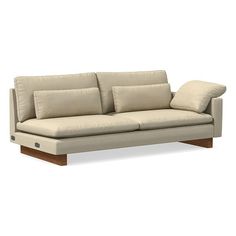 a light colored couch with two pillows on it's arms and backrests