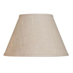 a lamp that is on top of a white wall with a beige shade over it