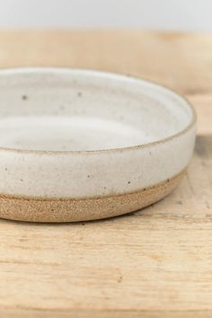 a white bowl sitting on top of a wooden table