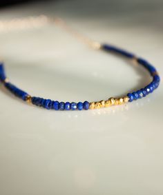 "Rows of faceted Lapis and glimmering Vermeil nuggets are artfully arranged with our Lyra Banded Gemstone Necklace. Perfect as a delicate solo piece or as a touch of color to add to your layers. The Lyra Necklace is currently available in Garnet, Lapis and Turquoise. If you would like to custom order this style in a different gemstone, please feel free to get in touch. We'd love to make it for you! DETAILS » Measurements: 16-19\" adjustable length » Materials: Lapis Faceted Gemstones | Vermeil a Sapphire Faceted Beads Jewelry Gift, Sapphire Rondelle Jewelry Gift, Blue Beaded Rondelle Jewelry, Sapphire Rondelle Jewelry For Gift, Sapphire Beaded Jewelry Gift, Sapphire Beaded Jewelry For Gifts, Spiritual Lapis Lazuli Jewelry With Faceted Beads, Spiritual Lapis Lazuli Necklace With Faceted Beads, Sapphire Beaded Rondelle Jewelry