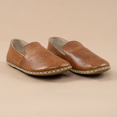 Brown Leather Slip-on Shoes With Stitched Sole, Artisan Brown Slip-on Moccasins, Brown Walking Shoes With Rubber Sole And Swift Leather, Brown Swift Leather Walking Shoes With Rubber Sole, Slip-on Leather Shoes With Closed Toe, Brown Plain Toe Walking Shoes With Stitched Sole, Brown Leather Loafers With Soft Sole, Slip-on Walking Shoes With Leather Footbed, Brown Swift Leather Slip-ons With Round Toe