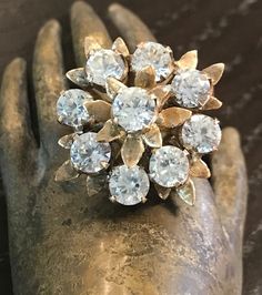 a close up of a person's hand wearing a ring with diamonds on it